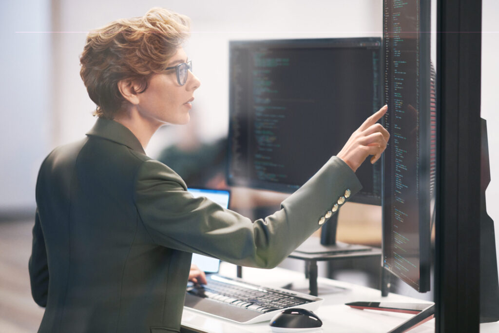 Person looking at and pointing to monitor.