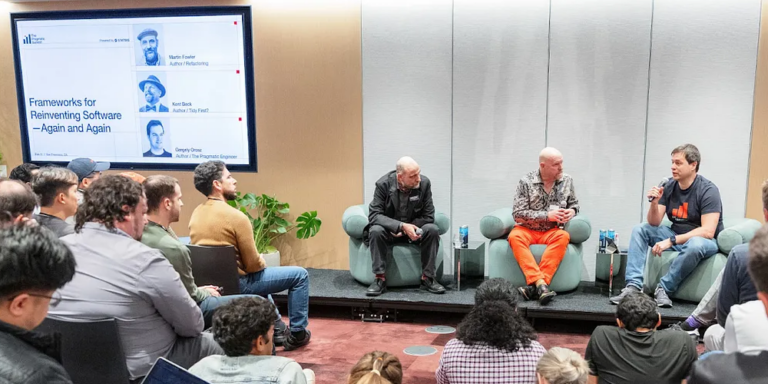 A photo of Gergely, Kent, and myself on the stage. We are all bedazzled by the vibrancy of Kent's trousers
